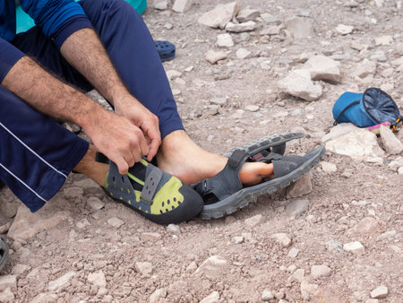 Young man changing shoes for rock climbing, bouldering conceptの写真素材