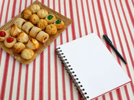 Homemade sweet panellets dessert, a typical pastry from Catalonia, Spain, on the All Saints festival. Notepad and pen for copy space. Food concept.の写真素材