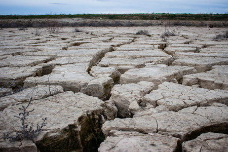 cracks in dry soil. Global warming causes rain not to fall, causing drought. Cracked surface. Concept of global warmingの写真素材