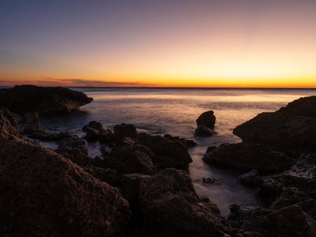 Sunrise in a small cove on the Costa Dorada in Tarragona, Spain.の写真素材