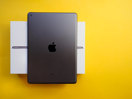 Lleida, Spain - February 28, 2023 : Studio photo of the new gray Apple iPad, logo from rear view. Isolated on yellow background. Illustrative editorial content.のeditorial素材