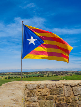 Flag waving in the wind in a high place, symbol of free Catalonia.の写真素材