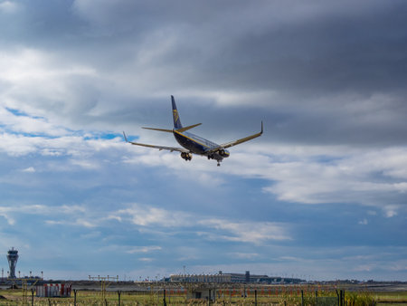 BARCELONA- SPAIN: December 16, 2022: Ryanair plane landing at Barcelona airport. View of airport and control tower.のeditorial素材