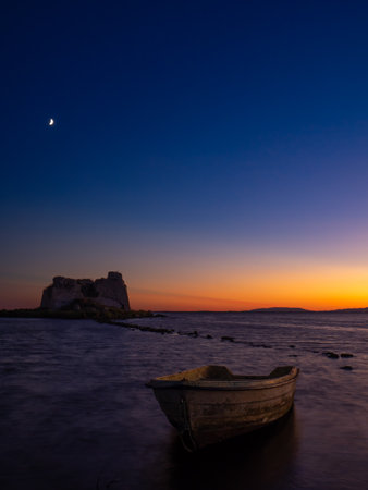 Beautiful sunset in the delta of the Ebro river next to the tower of Sant Joan and an abandoned boat. Tarragona, Spainの写真素材