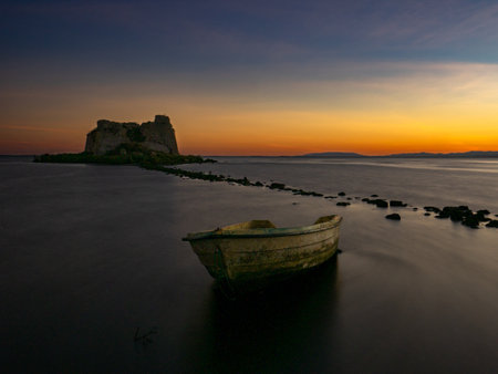 Beautiful sunset in the delta of the Ebro river next to the tower of Sant Joan and an abandoned boat. Tarragona, Spainの写真素材