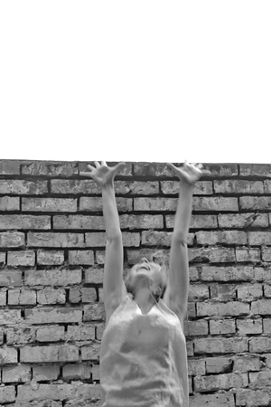 Girl in a gray dress on brick wall backgroundの写真素材