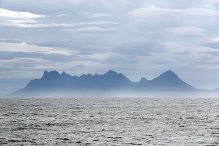 Ocean with Mountain Range in Mist, Norwayの写真素材