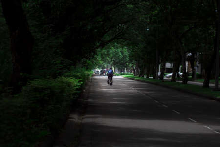 Bangkok,Thailand-August 8,2020: Cyclists through dense treesのeditorial素材