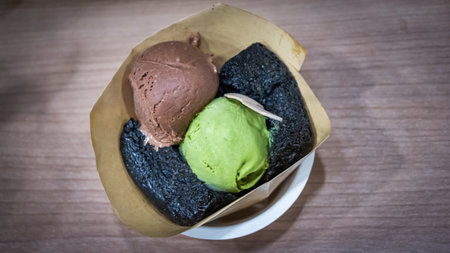 Charcoal bread or black bread, white cream and ice cream in the black dishの写真素材