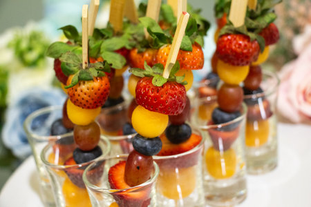 Fruit canapes on a white plate. Banquet table.の写真素材
