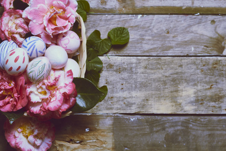 backgrounds made with camellias, green leaves and hand-painted easter eggsの写真素材