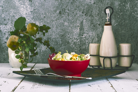 fresh salad in red bowl on gray backgroundsの写真素材