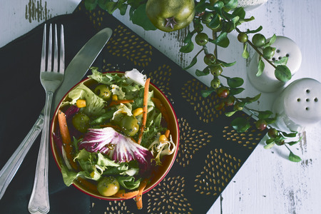 fresh salad in red bowl on gray backgroundsの写真素材