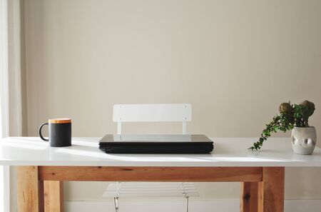 wooden table with coffee cup computer and a plant