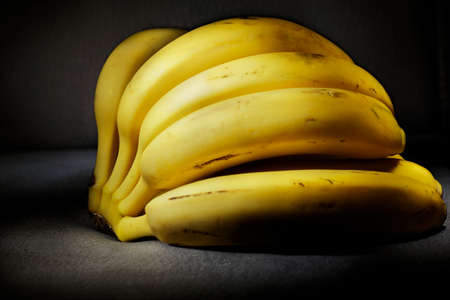 Ripe bananas unseparated on a gray backgroundの写真素材