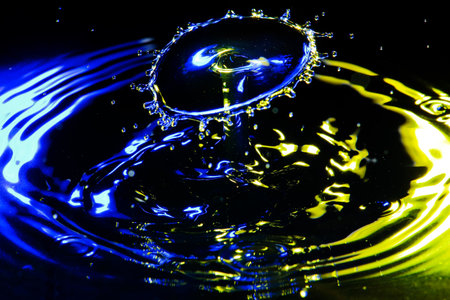 the exact moment when two drops of water collide in a container, forming a peculiar shapeの写真素材