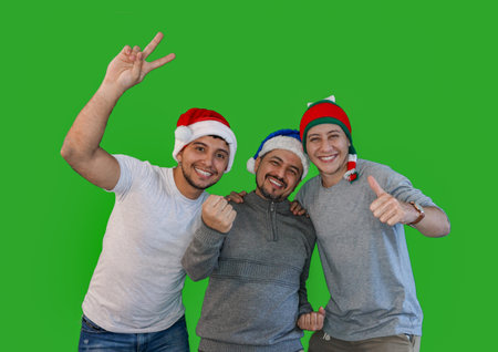 Three Latino men in Christmas hats, smiling and excitedly celebrating Christmas together.concept of Christmasの写真素材