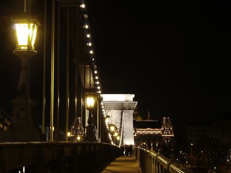 Chain bridge at night time with cars.の写真素材