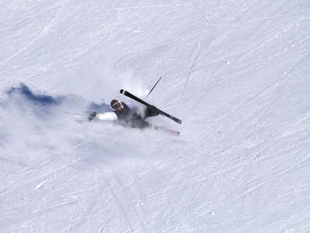 A smiling skier fall on the ski slope.の写真素材