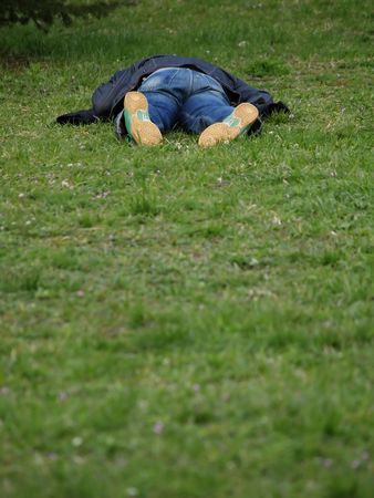A tired man lying on the grass.     の写真素材