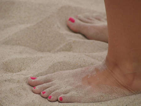 Feet with pink toes at the sandの写真素材