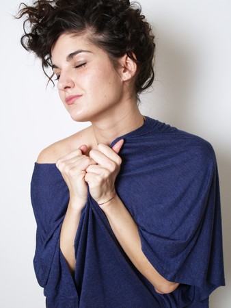 Young woman in blue t-shirt hugging herselfの写真素材