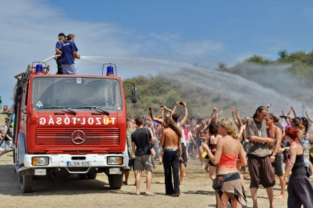 OZORA - AUGUST 12  Fireman splashing water on the crowd on Ozora Festival, one of the greatest psychedelic music gathering in Euorpe  Ozora, Hungary, Europe August 12, 2012 のeditorial素材