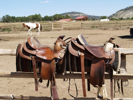Saddles with a horse in the backgroundの写真素材