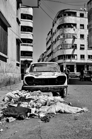 Trash and wrecked car on the streetの写真素材