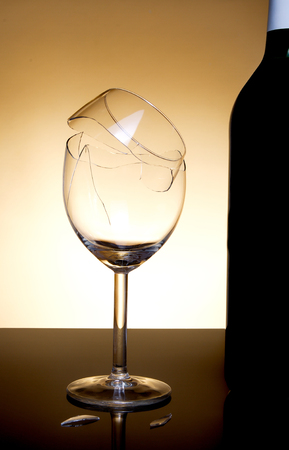 Vine bottle and broken glass on orange backgroundの写真素材
