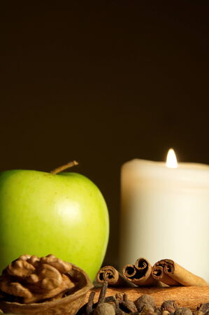Green apple, cinnamon, walnut and a candleの写真素材