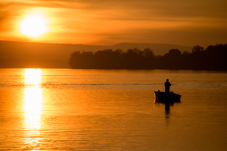 Fishing on a boat at sunsetの写真素材