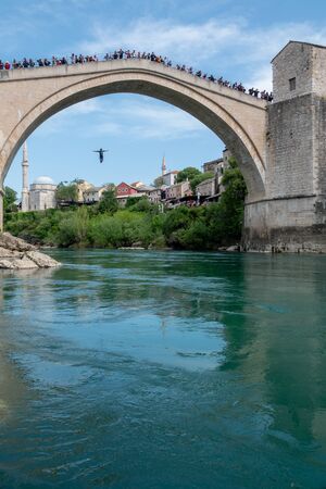 MOSTAR, BOSNIA- APRIL 21: Man jumping from old bridge on APRIL 21, 2019 in Mostar, Bosnia. It is a tradition for men to dive off the 21m bridgeのeditorial素材