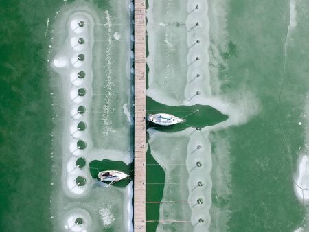Boats frozen in the water on lake Balaton, Hungaryの写真素材