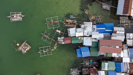 Fishing boats and stilt houses over the water in Bohol, Philippinesの写真素材