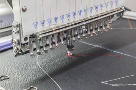 The embroidery machine embroider threads on fabric in the workshop