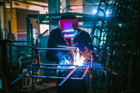 The welder works with metal at the factoryの写真素材