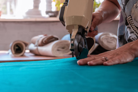 The cutter cuts the fabric with a disc knife in a sewing workshop