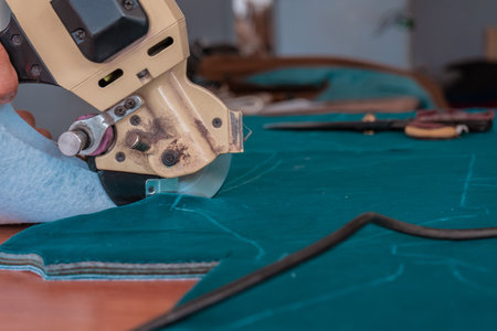 The cutter cuts the fabric with a disc knife in a sewing workshopの写真素材
