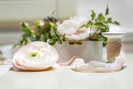 The elements of the wedding decor and invitation. Soft pastels and a rose flower. Bokeh background.