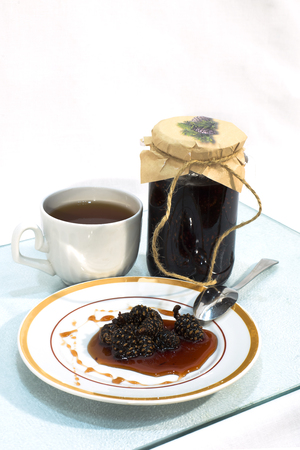 Jam made from pine cones on a plate and a cup of teaの写真素材