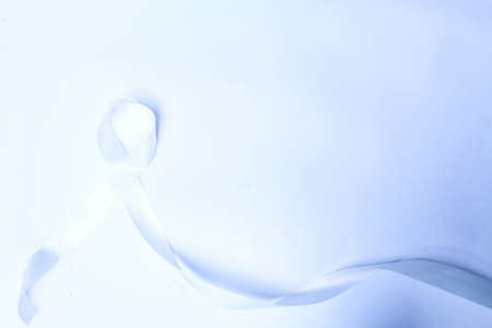 Blue ribbon symbol of fight against child abuse, symbol of education, prostate cancer, water accidents on isolated blue background.の写真素材
