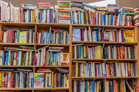 Kailua, Hawaii/USA- Dec. 30, 2019: Piles of used books on wooden shelves for sale in a used bookstore in Kailua, Hawaiiのeditorial素材