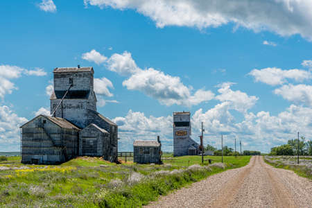 Horizon, Saskatchewan, Canada- July 18, 2020: Main road leading past the abandoned Wheat Pool and Federal grain elevators in the ghost town of Horizon, Saskatchewan, Canadaのeditorial素材