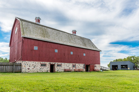 Abernethy, SK- Aug. 21, 2022: W. R. Motherwellâs historic barn from 1907 with farming equipment in the background, on his homestead, Lanark Place, now a National Historic Siteのeditorial素材