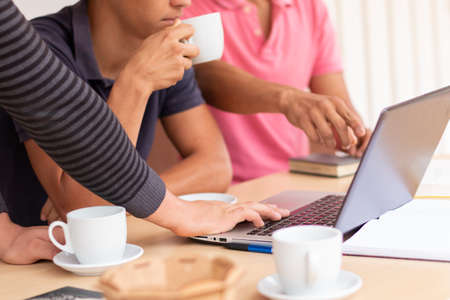 Group of three businessmen using laptop on desk. Concept of business