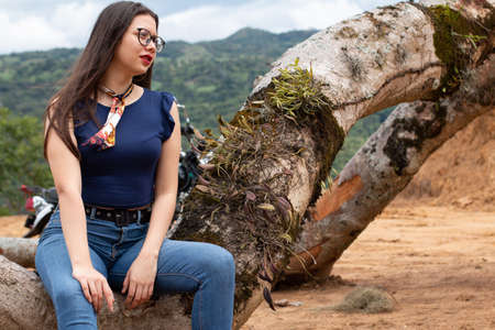Woman posing in the jungle on felled tree.の写真素材