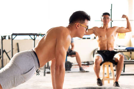 Big man doing push-ups in rustic gym.の写真素材