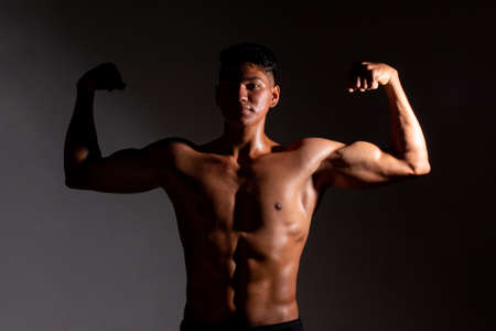 Slim and muscular young man posing with his naked torso.の写真素材