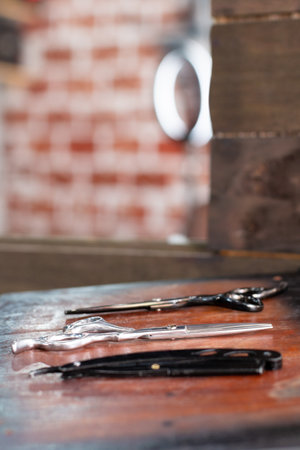 Hairdressing machine and razor blade on wood. Barber accessories.